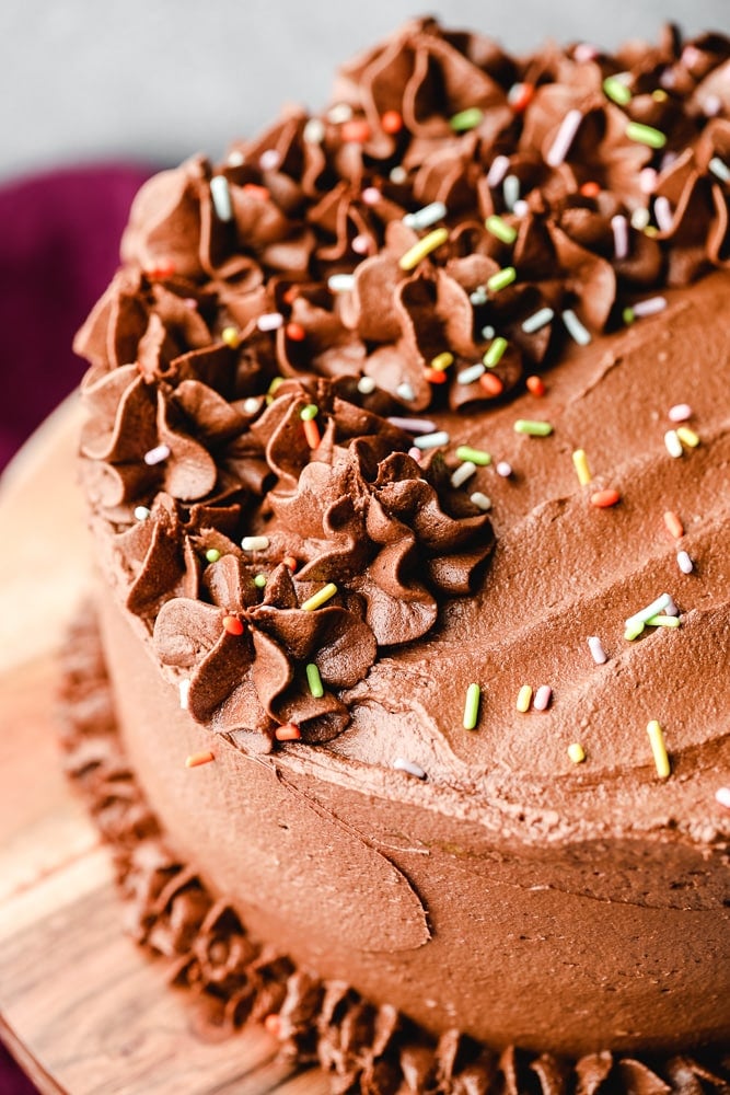 a round chocolate-frosted cake with colorful sprinkles on top.