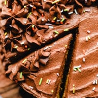 Removing a slice of chocolate-frosted cake.