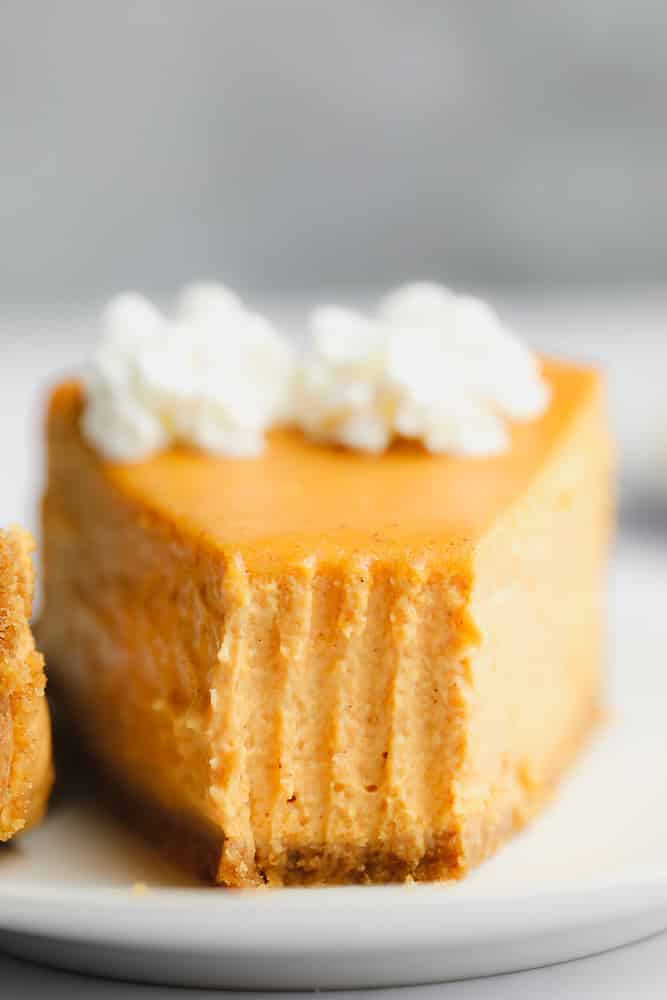 close up on a slice of pumpkin cheesecake with a bite missing.