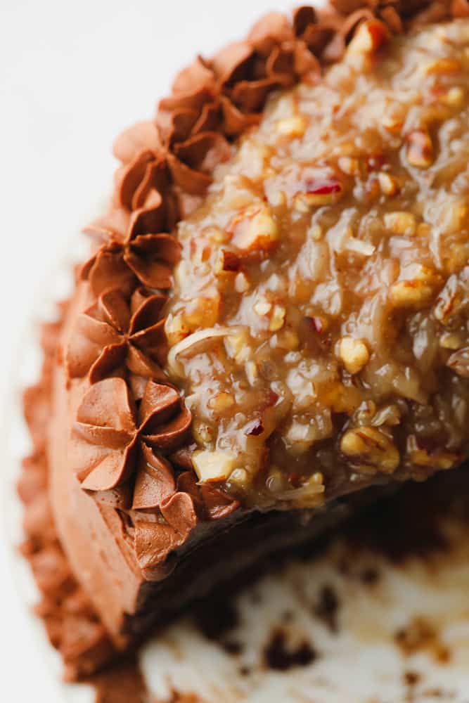 Close up on a frosted chocolate cake with a pecan caramel sauce on top.