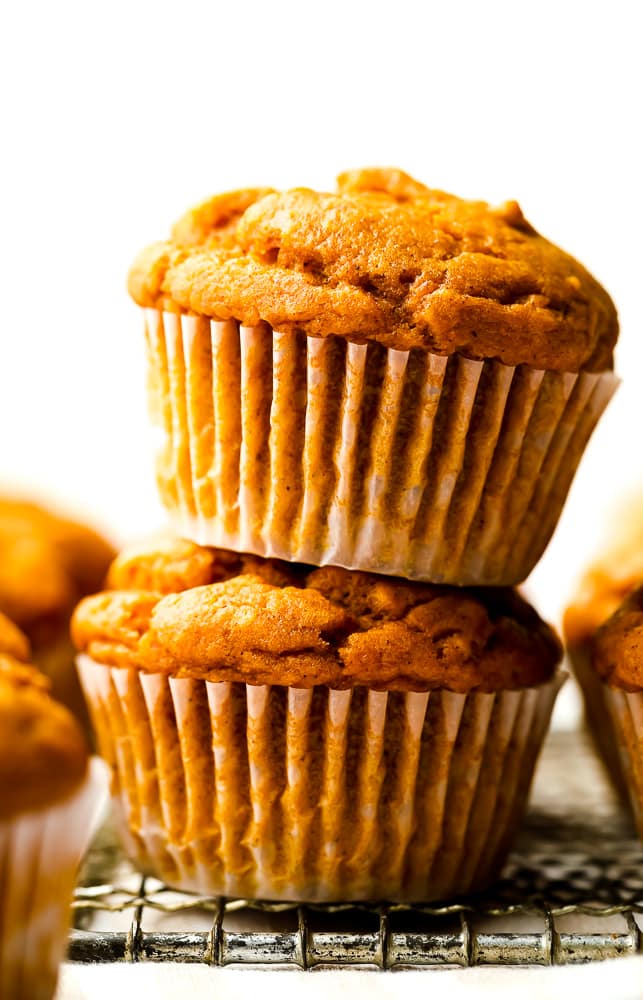 stack of two muffins that are orange, white background