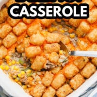 pinterest image of a metal spoon scooping some baked tater tot casserole out of a white casserole dish.