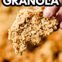pinterest image of a womans hand holding a cluster of granola.