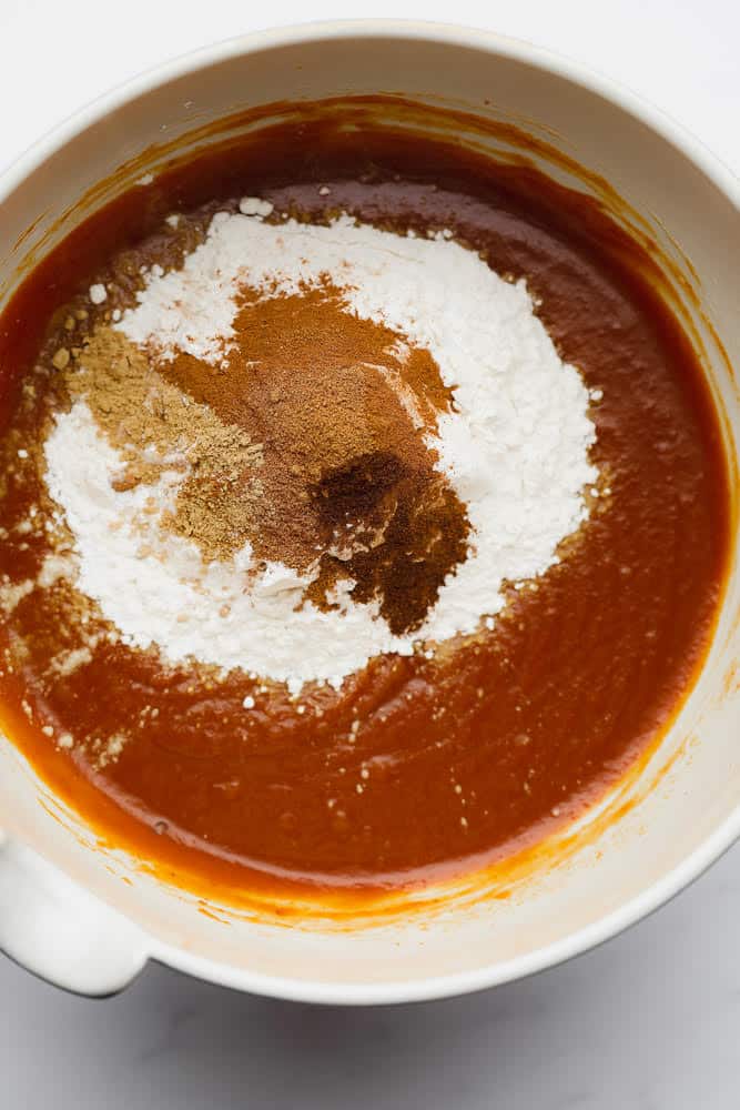 adding dry ingredients to wet in a bowl for muffins