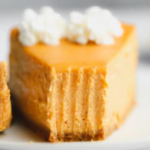 close up on a slice of pumpkin cheesecake with a bite missing.