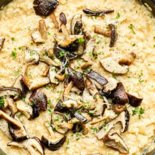 Close up on cooked mushrooms on top of creamy yellow risotto.