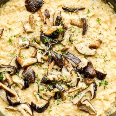 Close up on cooked mushrooms on top of creamy yellow risotto.
