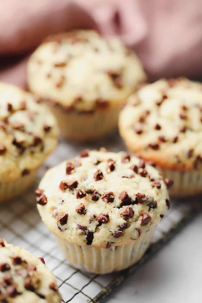 one muffin in focus, the rest of out focus with a pink towel in background