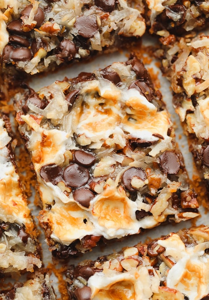 close up on a cut cookie bar with toasted marshmallows, coconut, and chocolate on top.