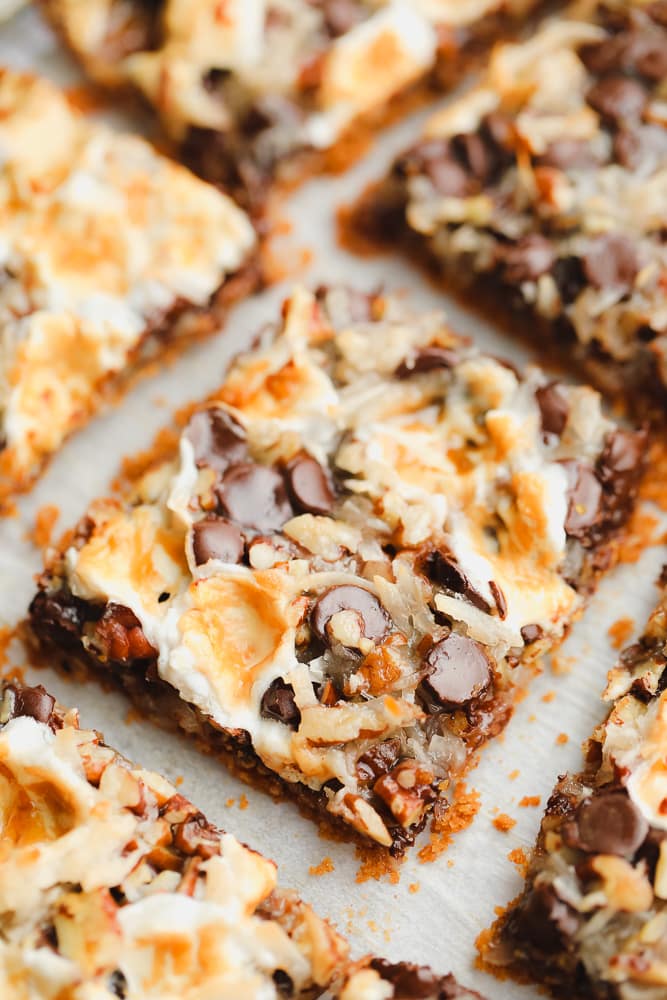 close up on a cut cookie bar with toasted marshmallows, coconut, and chocolate on top.