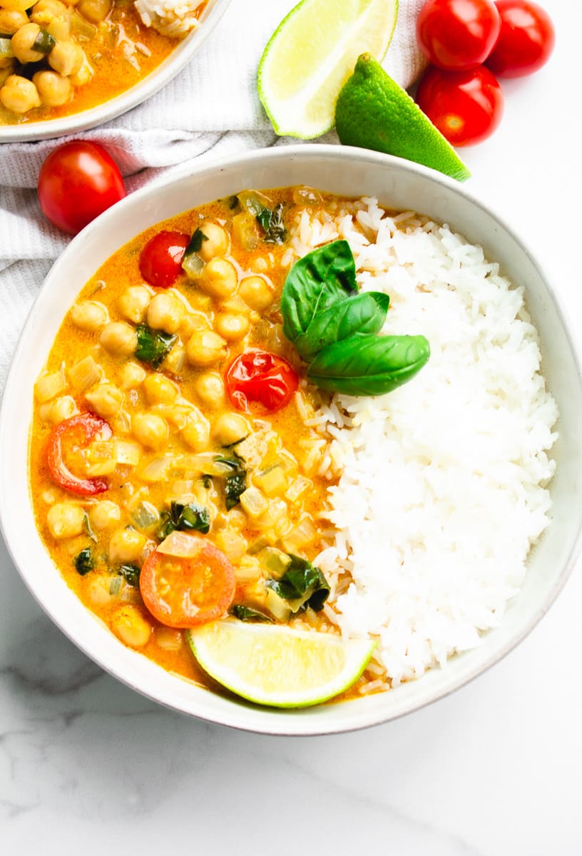 bowl of white rice and chickpea curry with tomatoes and basil