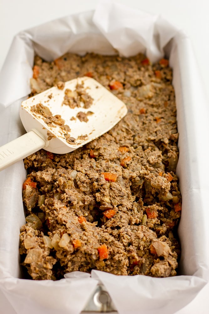 loaf pan lined with parchment and putting in loaf ingredients