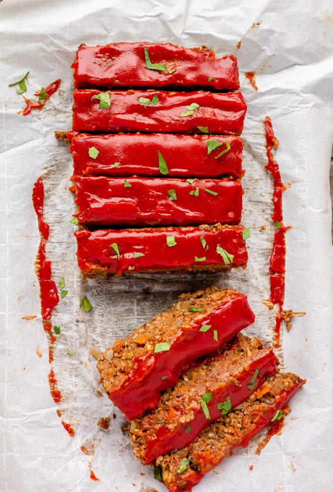 looking down on a lentil loaf sliced with green herbs on top
