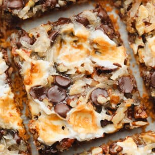 close up on a cut cookie bar with toasted marshmallows, coconut, and chocolate on top.