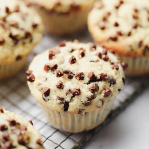 square image of a vegan chocolate chip muffin with more in background