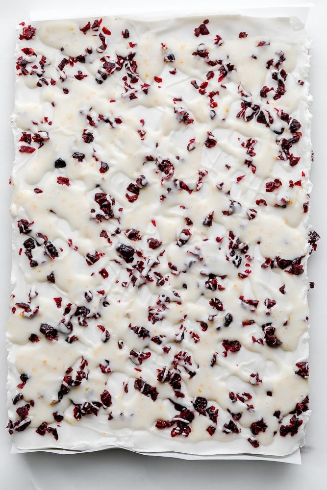 overhead view of vegan white chocolate cookie bars topped with dried cranberries.