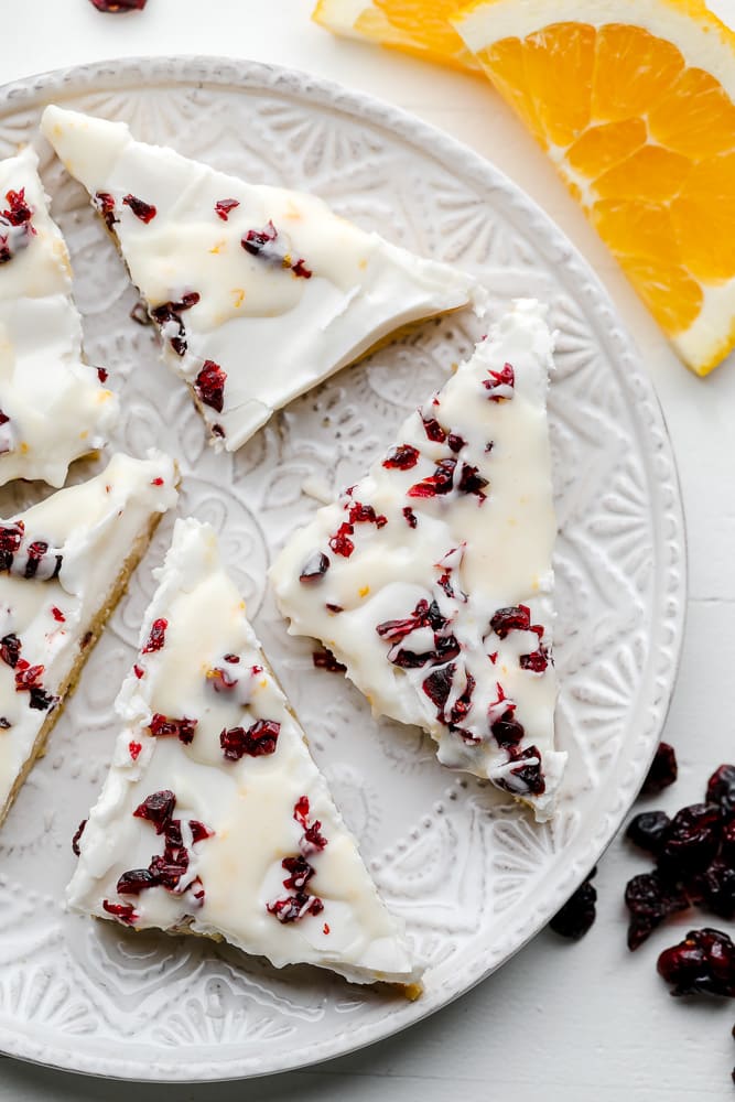 white chocolate and cranberry cookie bars on a decorative white plate.