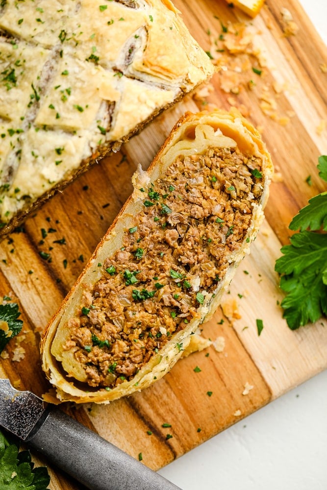 close up on a slice of vegan wellington on a wood board.