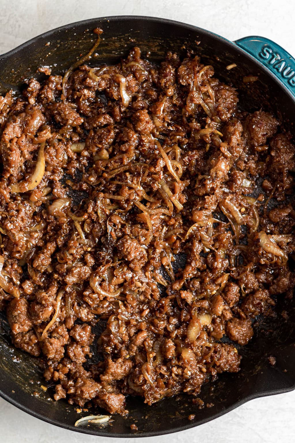 cooked vegan ground beef and onions in a black skillet.