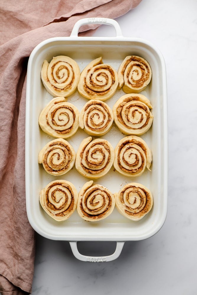 uncooked swirly rolls in dish with pink towel