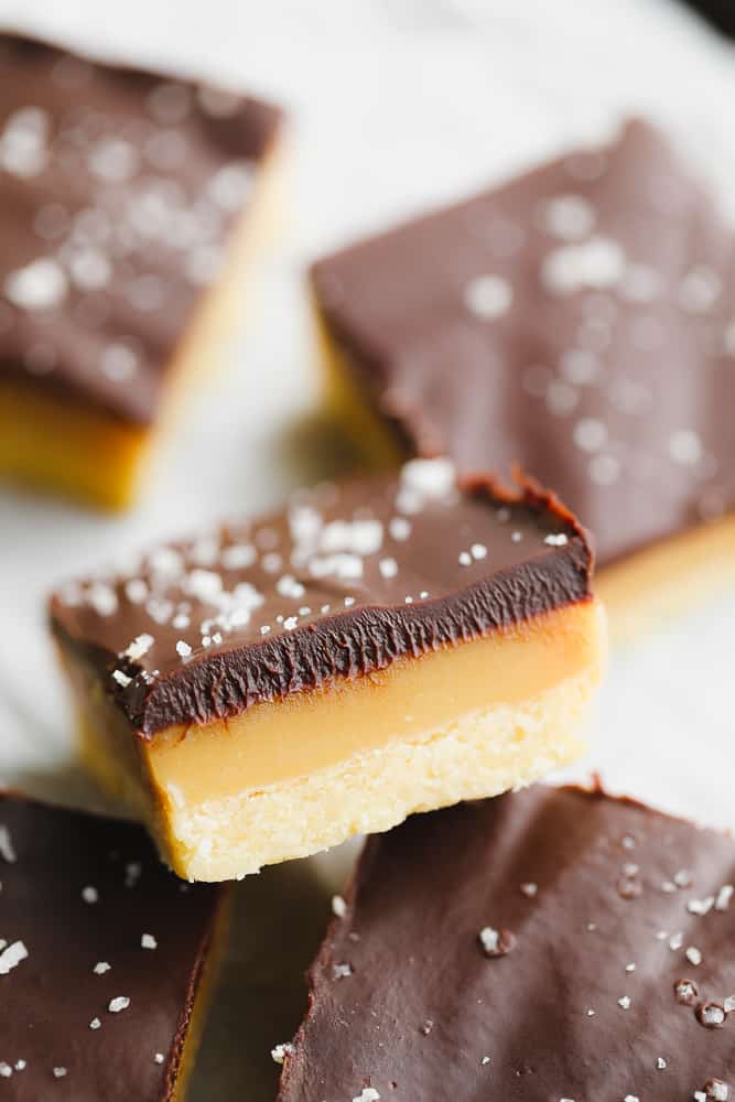 close up on a cookie bar with layers of shortbread, caramel, and chocolate.