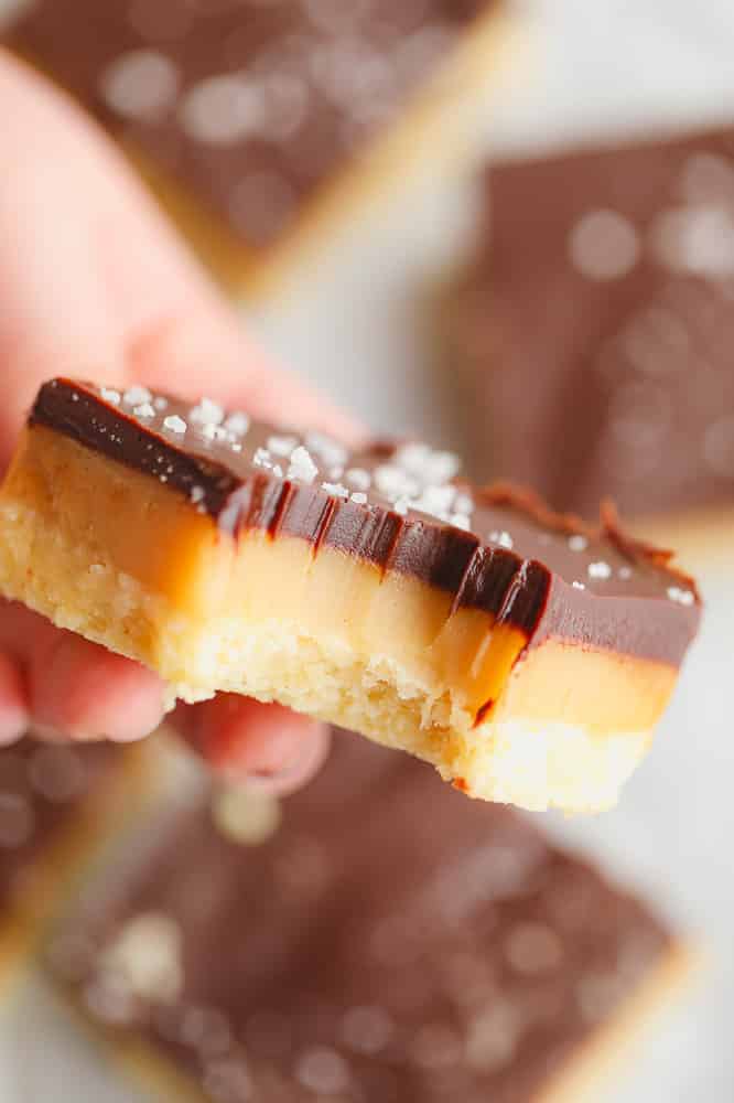 close up on a millionaire shortbread bar with a bite out of it.