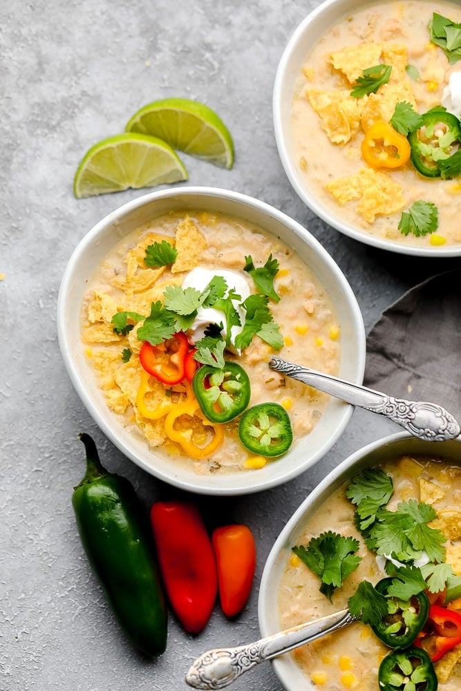 3 bowls of white chili on grey background