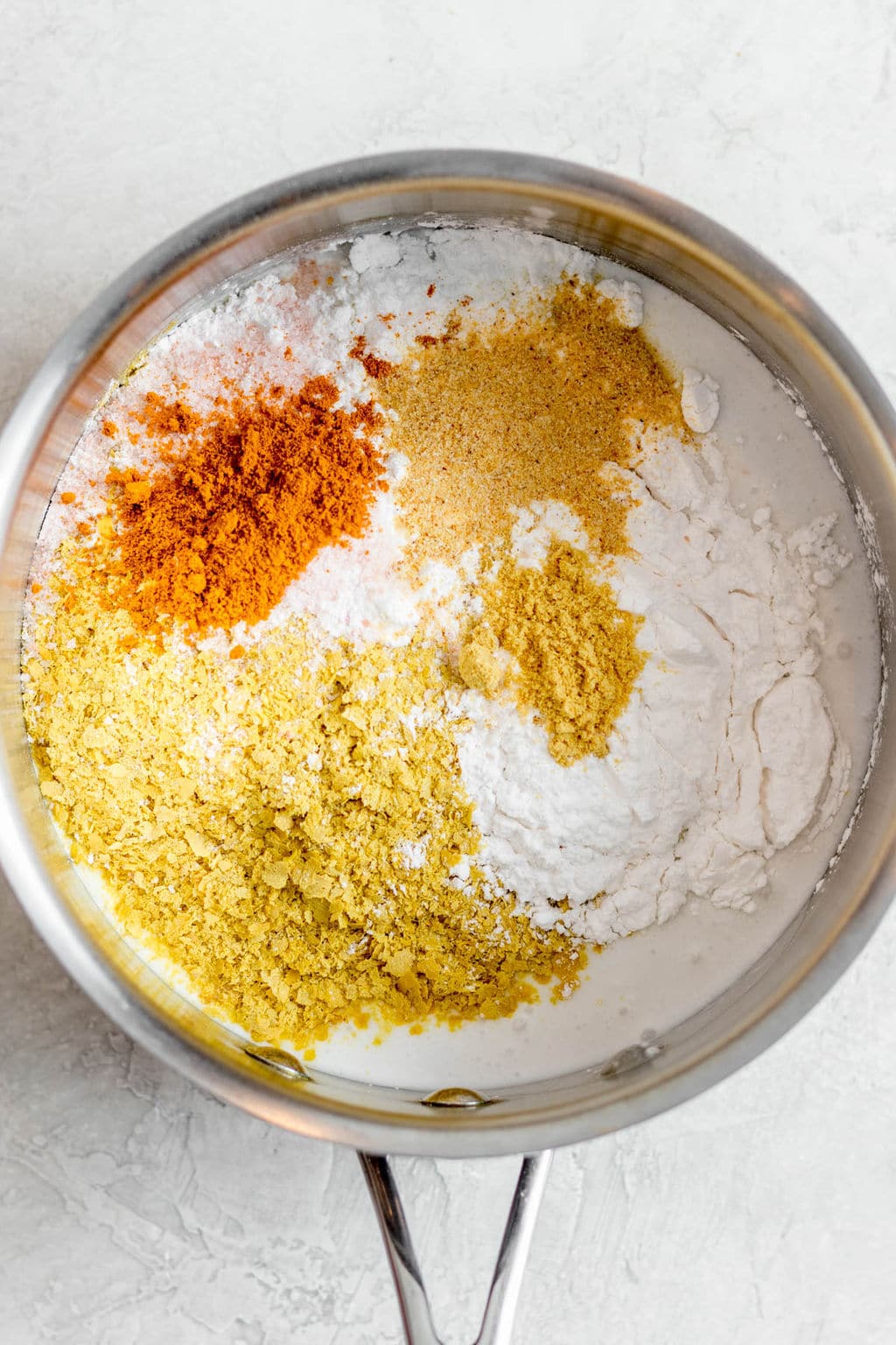 yellow and white seasonings in a metal pot.