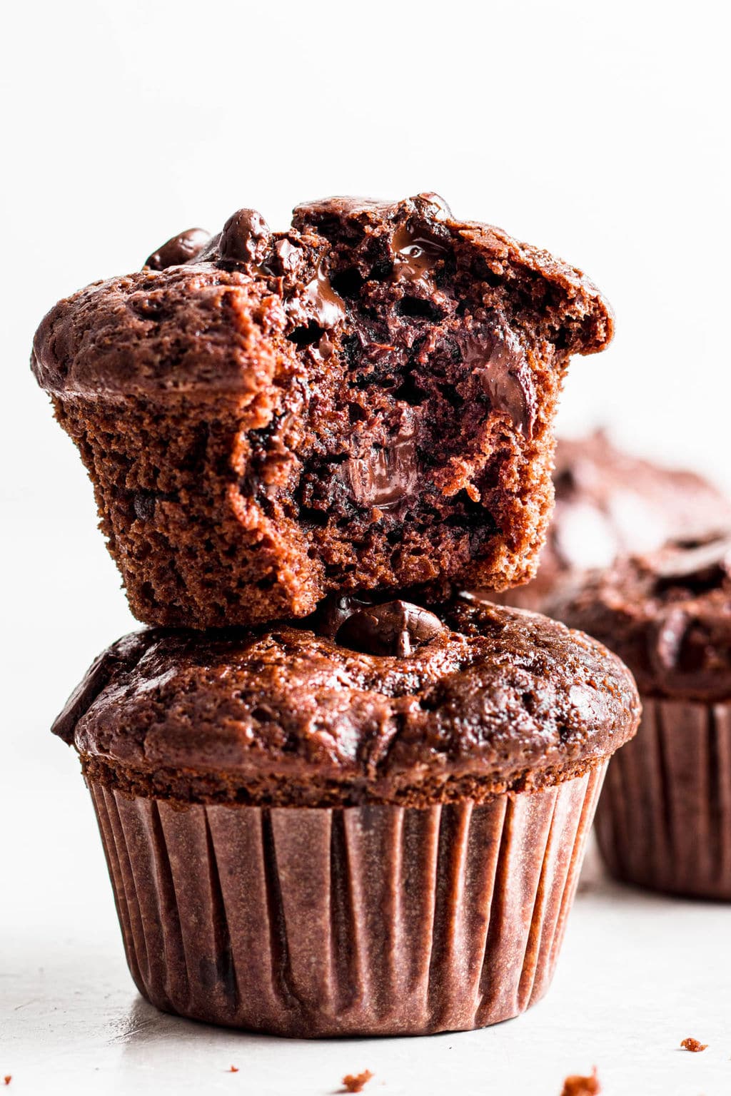 2 chocolate muffins stacked on top of each other.