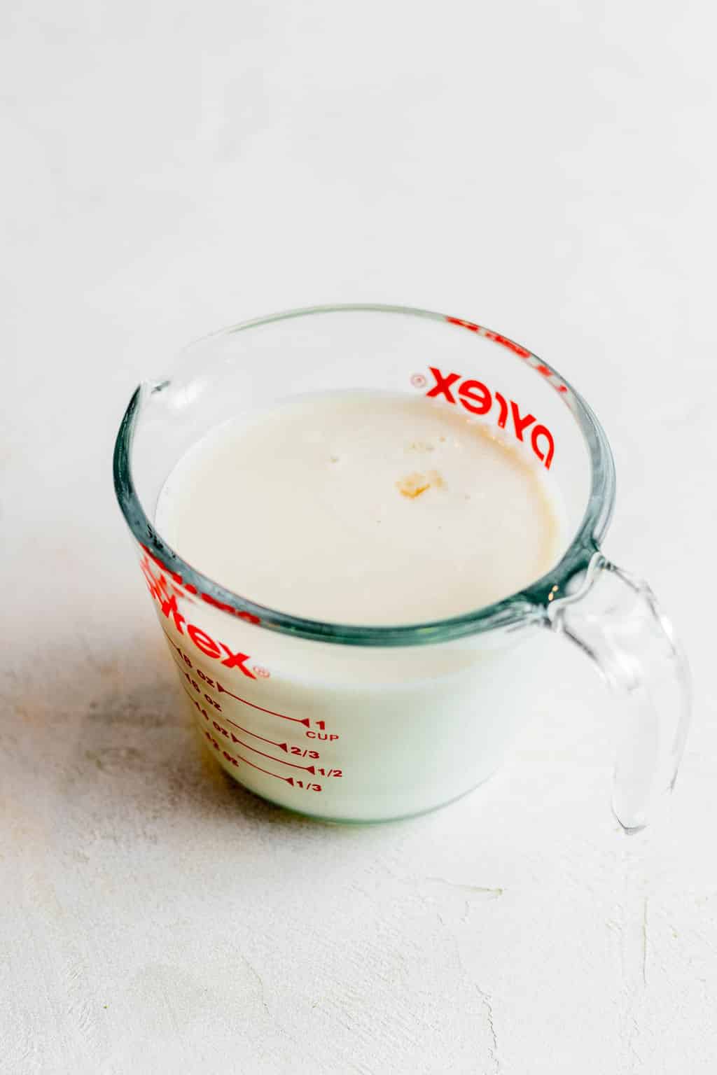 vegan milk and vinegar in a glass measuring cup.