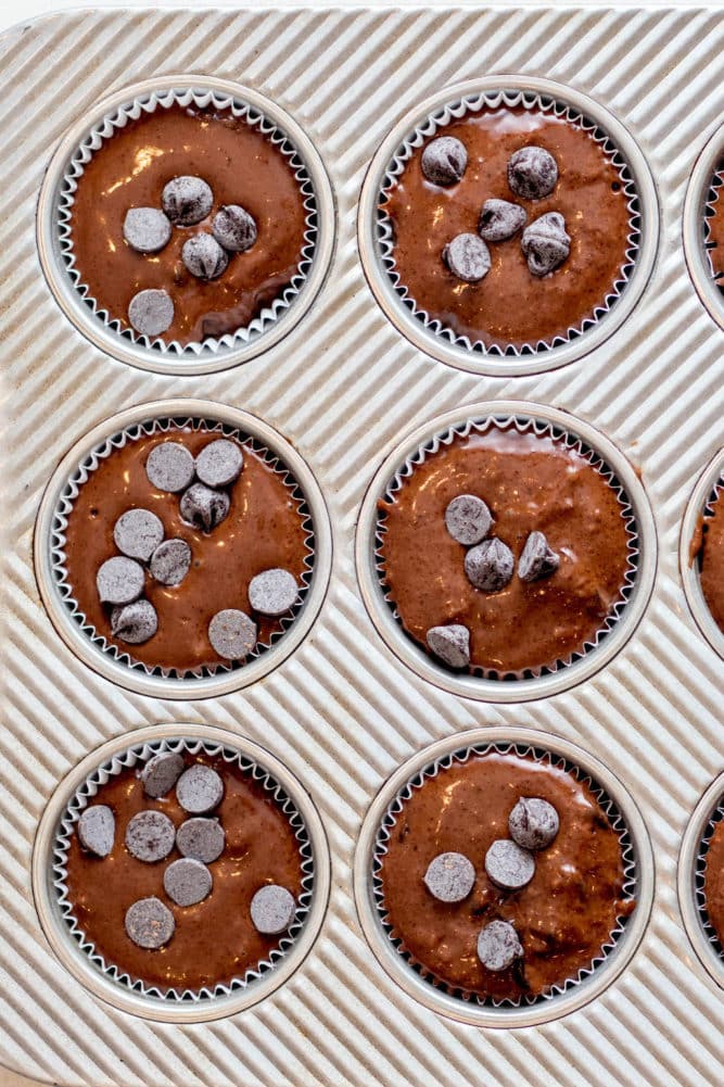 overhead view of chocolate muffin batter in a metal baking tin.