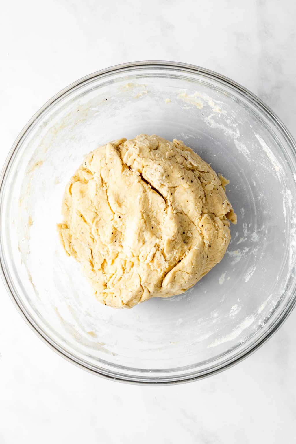 a rolled ball of dough in a glass bowl.