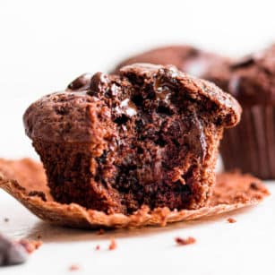 close up on a chocolate muffin with a bite out of it.