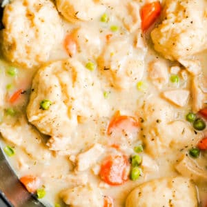 close up on vegan chicken soup and dumplings in a large black pot.