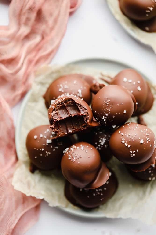 a pile of chocolate truffles with one missing a bite.