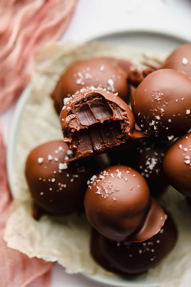 close up on a chocolate truffle with a bite taken out of it.