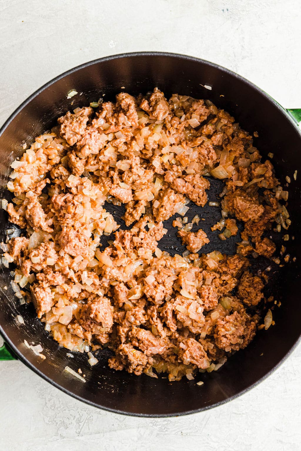 sautéing vegan ground beef in a large black pot.