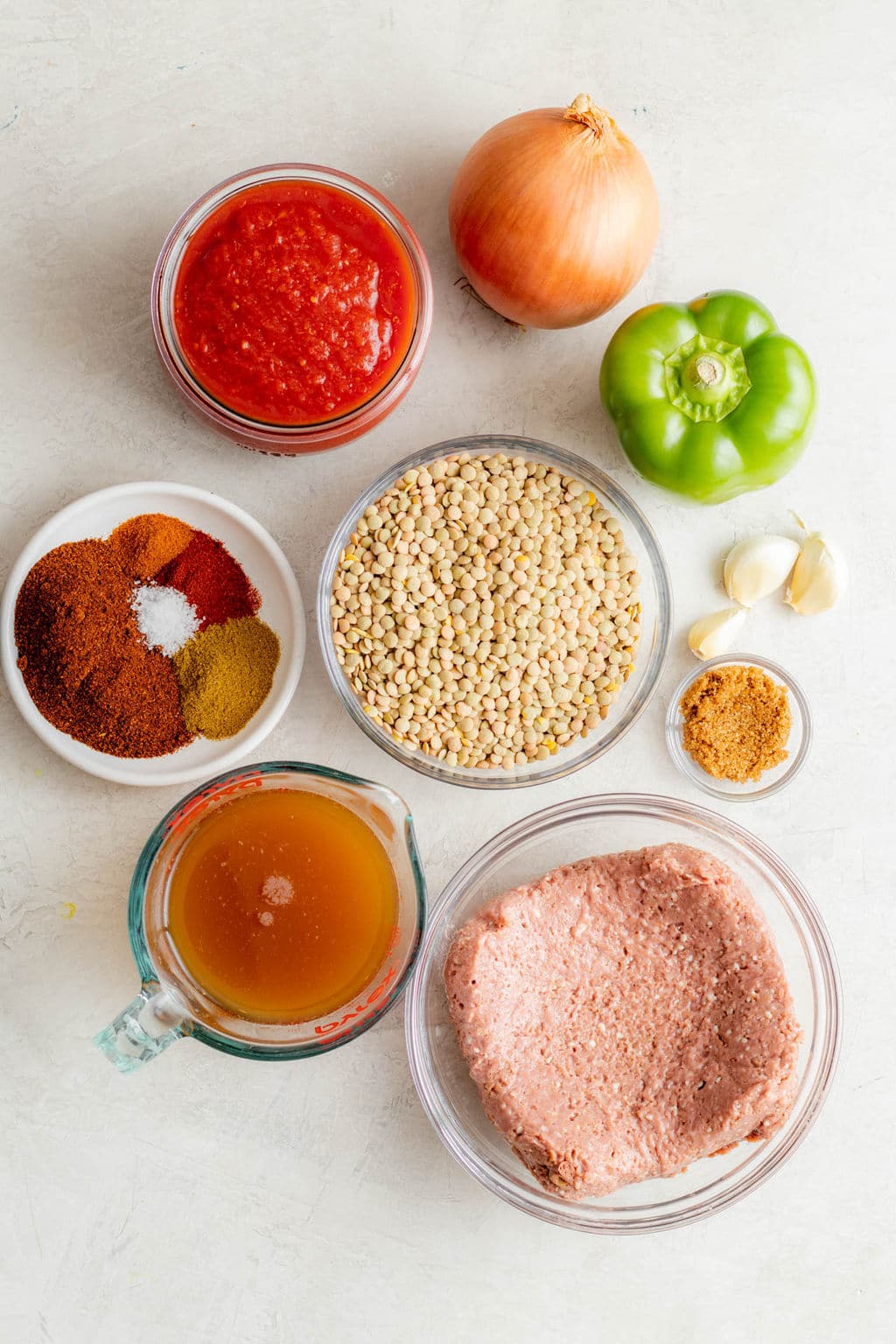 individual glass bowls filled with spices, tomato sauce, lentils, broth, and vegan ground beef.