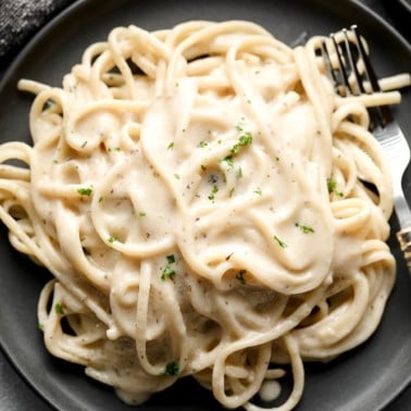 dark grey plate with pasta and creamy sauce