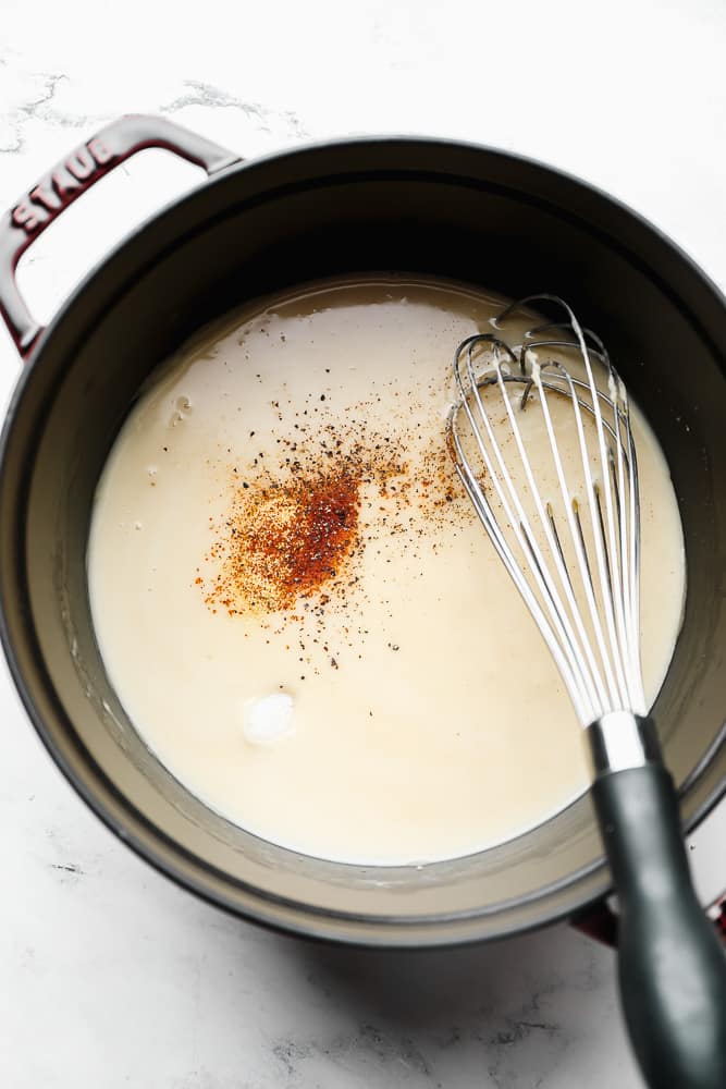 pot with milk mixture and spices, whisk in it