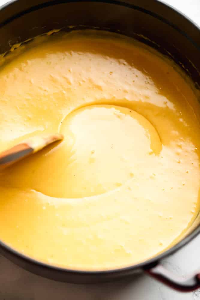 a spoon stirring cheese sauce in a pot