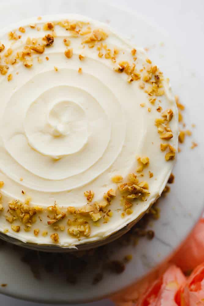 whole cake with swirly frosting and walnuts on the edges
