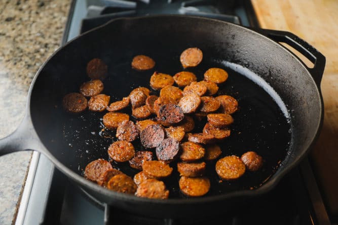 sausage cooking in a cast iron pan