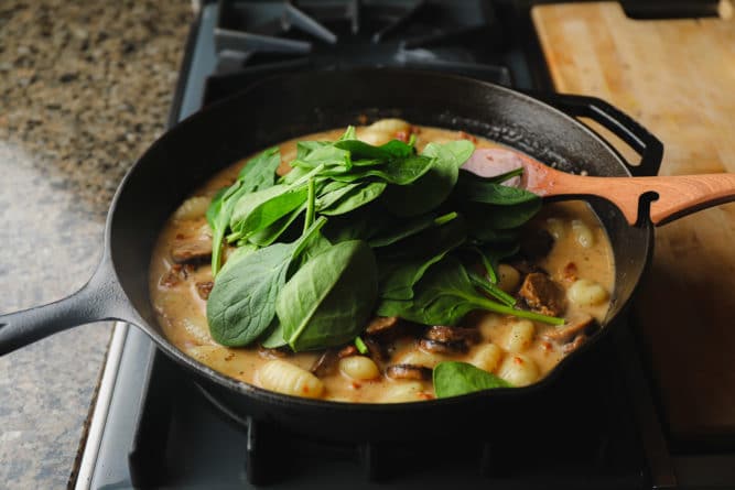 spinach added to a pan with gnocchi