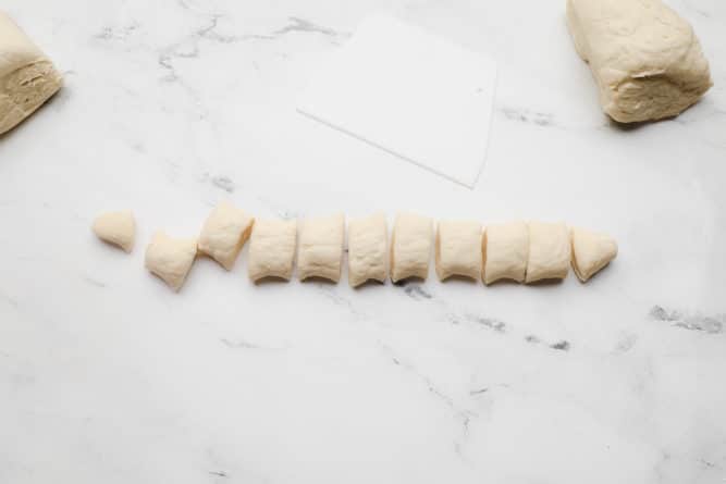 cut pieces of dough on a white marble background