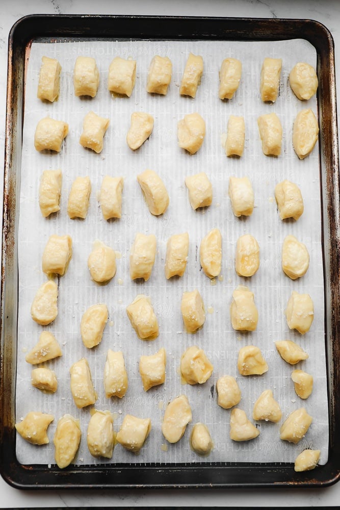 uncooked pretzel pieces on a baking sheet