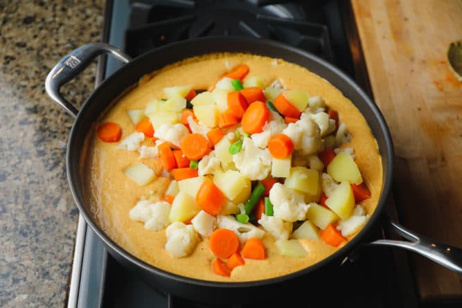 cooked potatoes and veggies added to sauce on stovetop