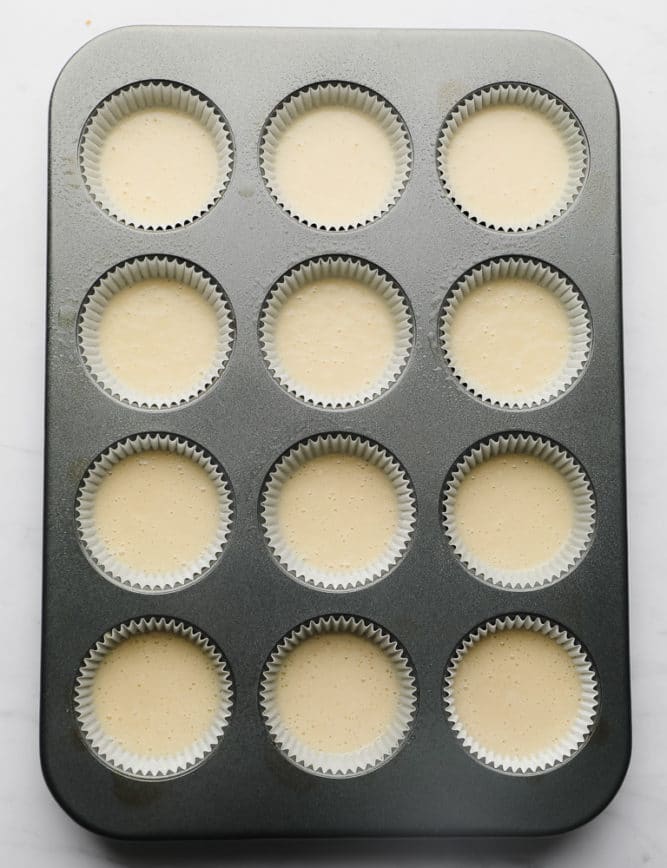 unbaked cupcake batter in a pan with liners