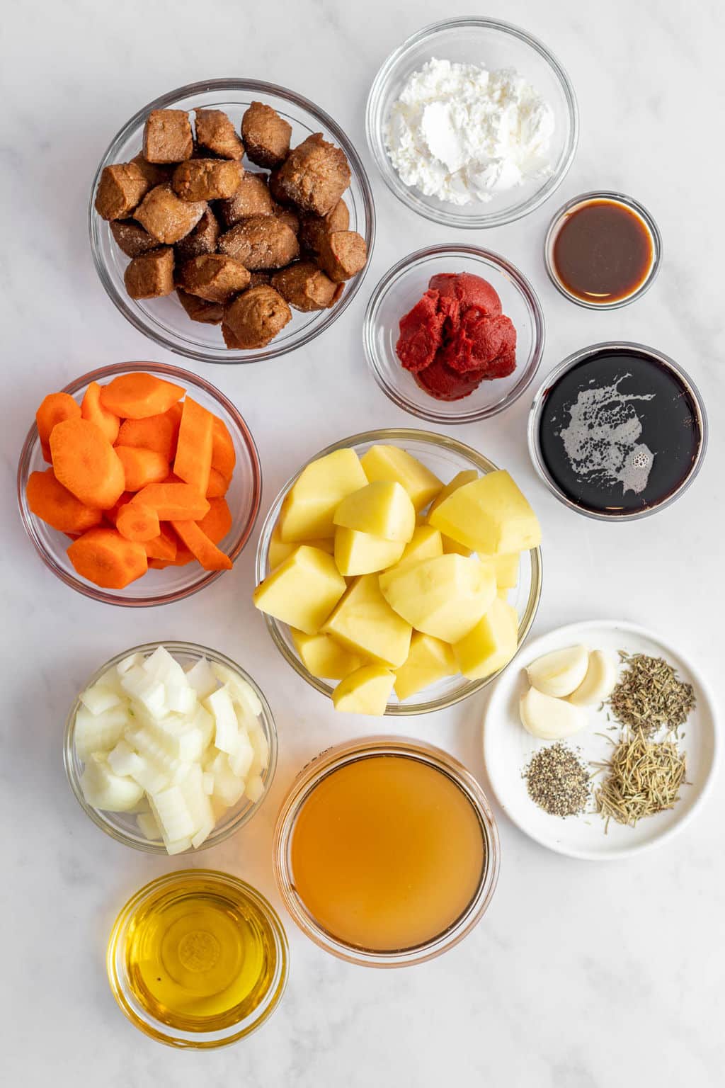 ingredients for vegan irish stew in individual glass bowls.