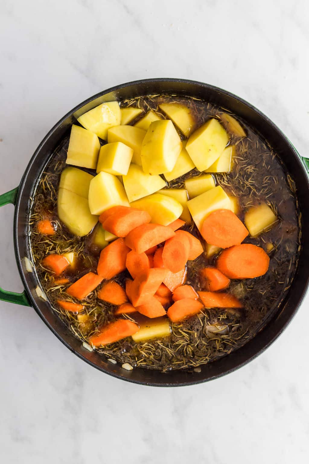 cooking potatoes and carrots in a large pot.